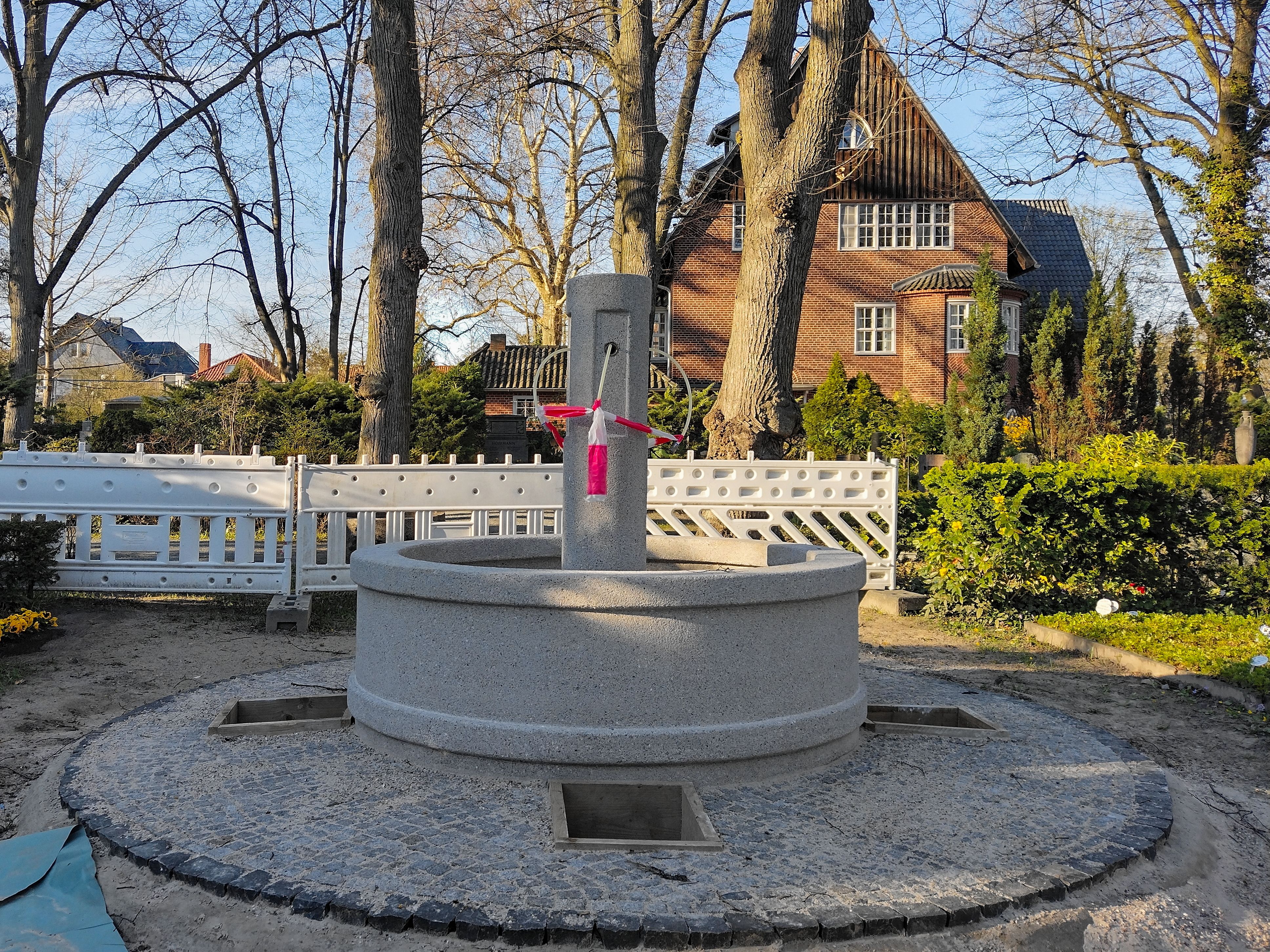 Steinerner Brunnen zwischen Bäumen auf dem Waldfriedhof Dahlem